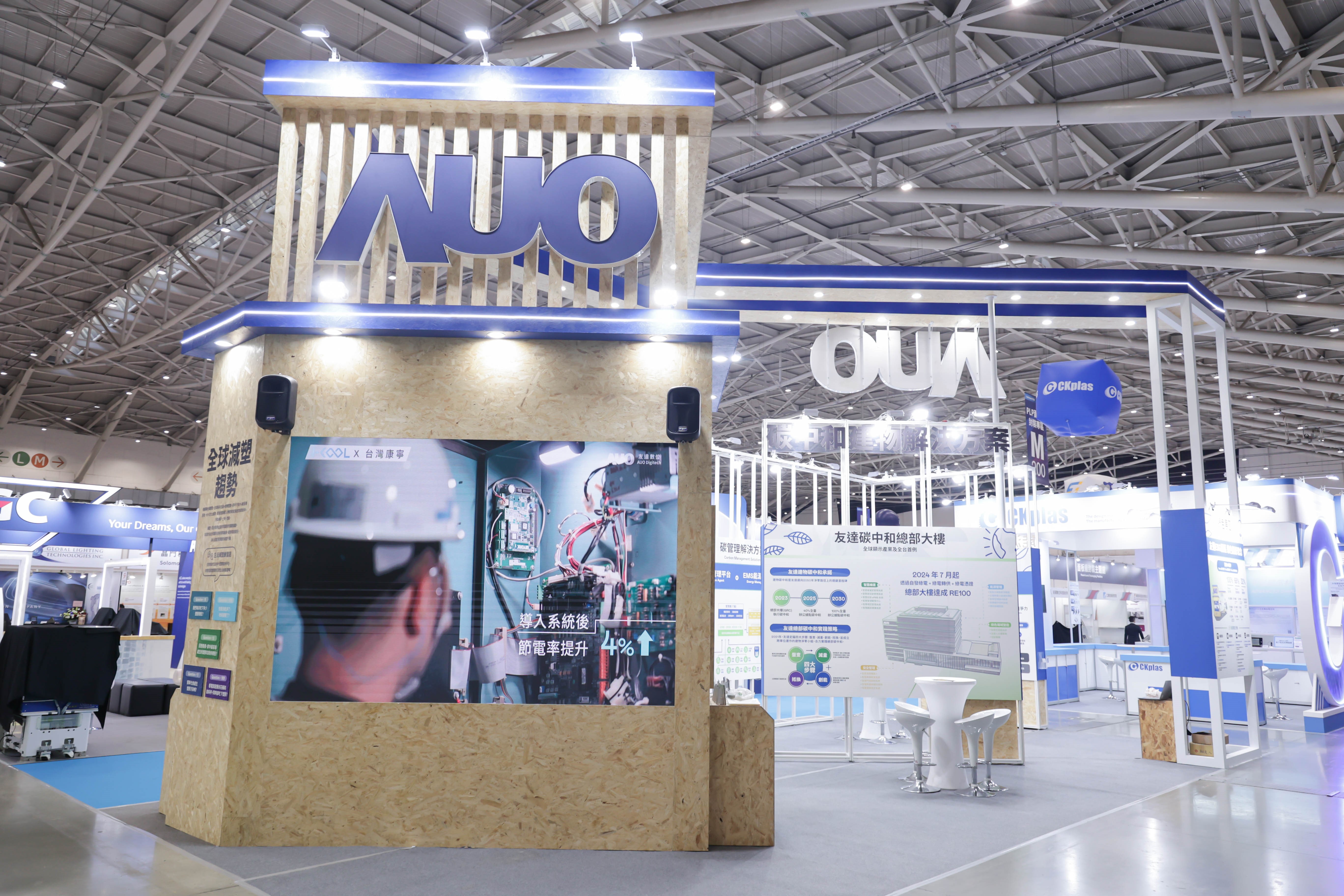 ⽜⼋体育淨零碳排與新能源展位全面採用可回收材料，包含整體採鋁柱組合結構，搭配甘蔗板呈現溫潤木質色調，並以租賃桌椅進行現場陳設，實現源頭減量。